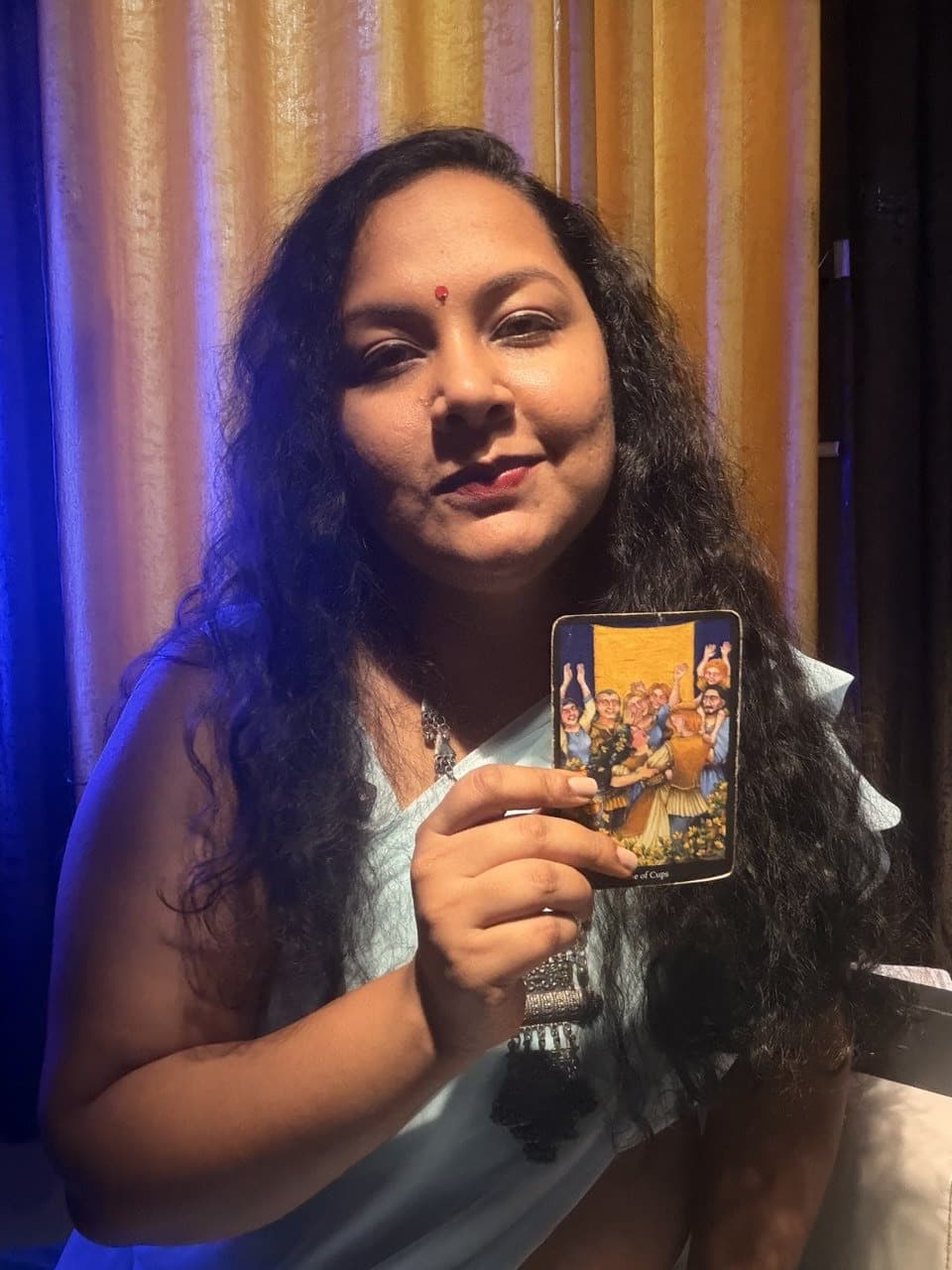 Sushmita holding a Tarot card